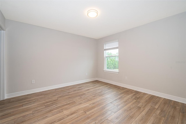spare room featuring light wood-style floors and baseboards