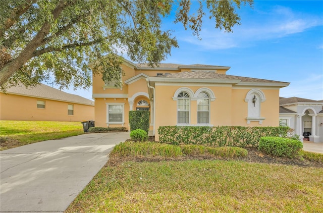 303 Plumoso Loop, Davenport, FL 33897 - mediterranean / spanish home featuring stucco siding, a front yard, and concrete driveway