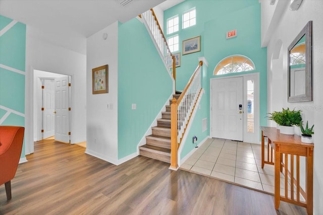 303 Plumoso Loop, Davenport, FL 33897 - foyer featuring a towering ceiling, stairs, wood finished floors, and baseboards
