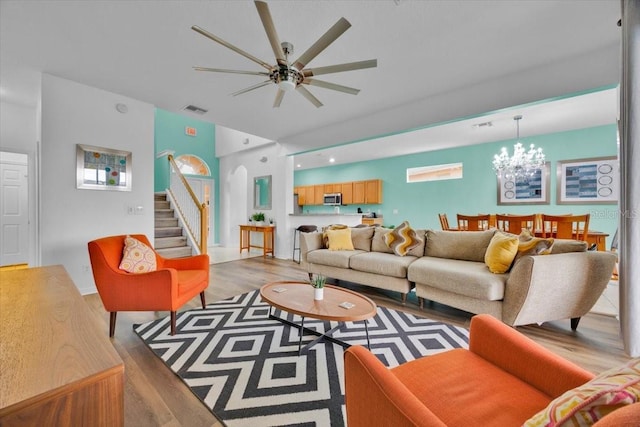 303 Plumoso Loop, Davenport, FL 33897 - living area with light wood finished floors, stairs, ceiling fan, and a chandelier