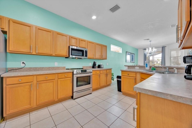 303 Plumoso Loop, Davenport, FL 33897 - kitchen featuring appliances with stainless steel finishes, a chandelier, a sink, a peninsula, and light tile patterned floors