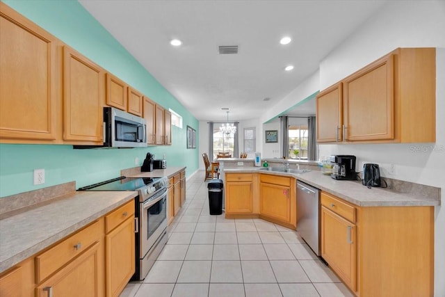 303 Plumoso Loop, Davenport, FL 33897 - kitchen with stainless steel appliances, a sink, light countertops, light tile patterned floors, and recessed lighting