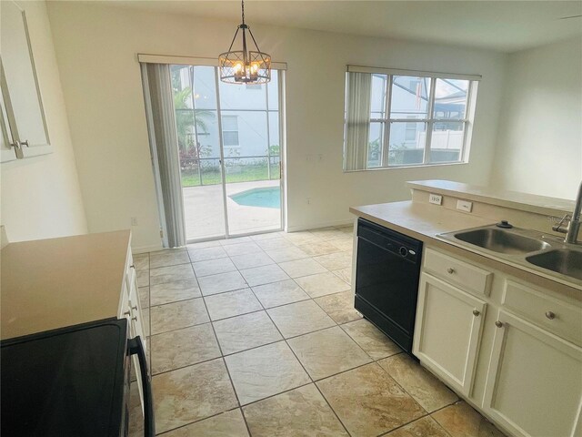 kitchen featuring black dishwasher, a sink, a chandelier, hanging light fixtures, and light countertops