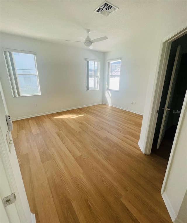 empty room with light wood-style flooring, baseboards, and ceiling fan