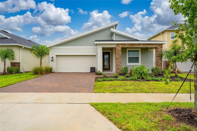 view of front facade featuring decorative driveway, a garage, a front lawn, and brick siding