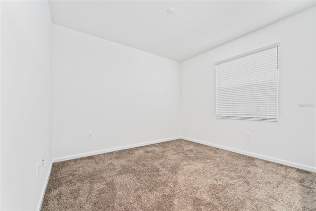 carpeted spare room with baseboards