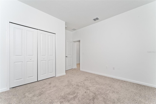 unfurnished bedroom with carpet, baseboards, and a closet