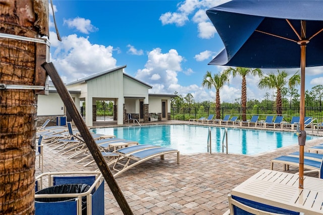 community pool featuring fence and a patio