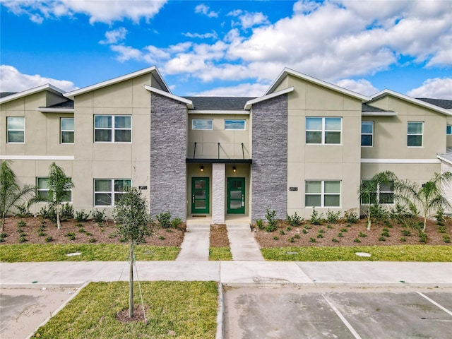 2970 Protagonist St, Kissimmee, FL 34746 - multi unit property with stucco siding, uncovered parking, stone siding, and a balcony