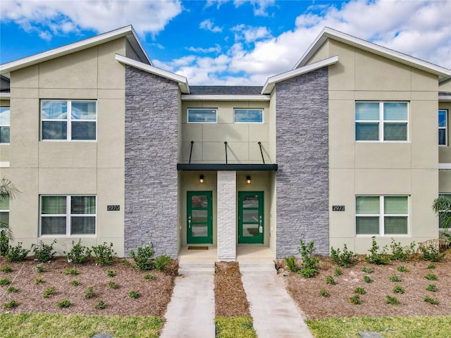 2970 Protagonist St, Kissimmee, FL 34746 - view of front of house with stucco siding, a balcony, and stone siding