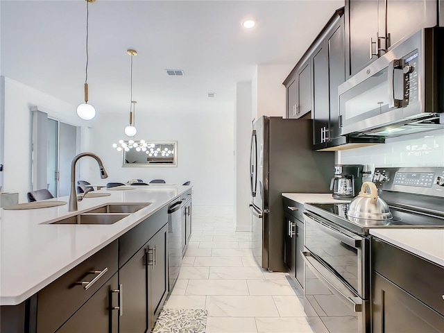 2970 Protagonist St, Kissimmee, FL 34746 - kitchen with appliances with stainless steel finishes, a sink, light countertops, light marble finish floors, and pendant lighting