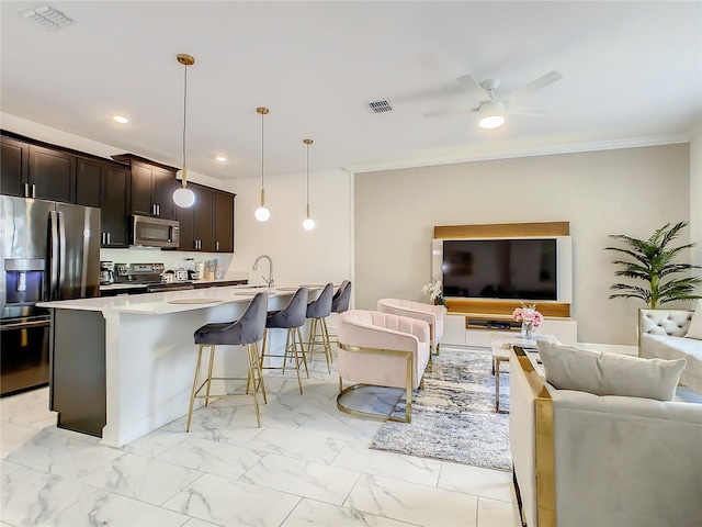 2970 Protagonist St, Kissimmee, FL 34746 - kitchen with stainless steel appliances, open floor plan, a kitchen breakfast bar, light marble finish flooring, and recessed lighting