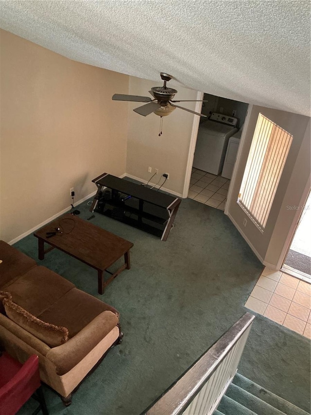 tiled living room featuring carpet floors, a textured ceiling, a ceiling fan, and baseboards