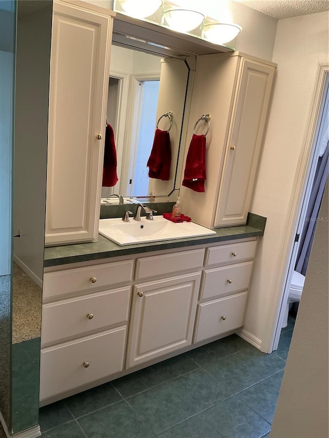 bathroom featuring vanity, tile patterned floors, and baseboards