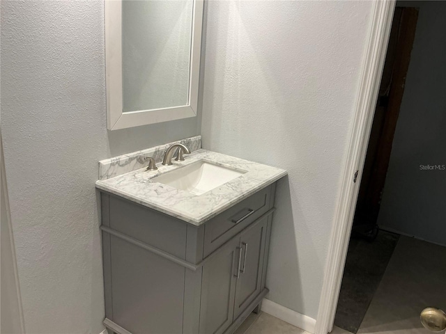 bathroom featuring vanity and a textured wall