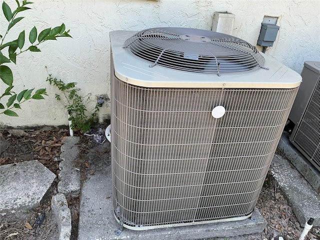 exterior view of central AC unit and stucco siding