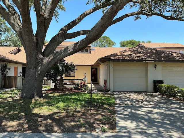 940 Fenton Ln Unit 8, Lakeland, FL 33809 - view of front facade with a garage, stucco siding, driveway, and a shingled roof