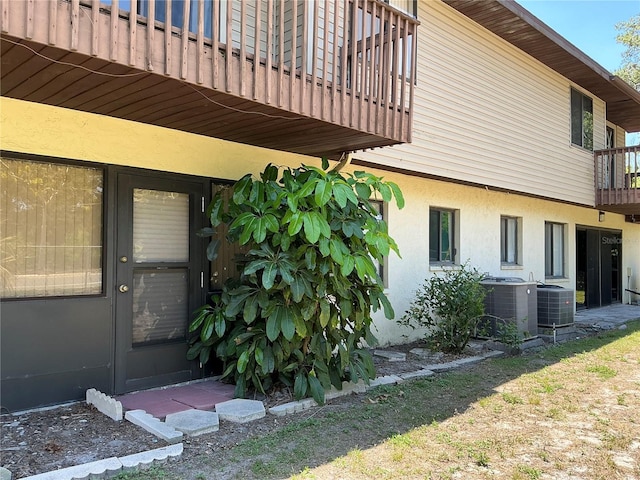 940 Fenton Ln Unit 8, Lakeland, FL 33809 - property entrance with a balcony, stucco siding, and cooling unit