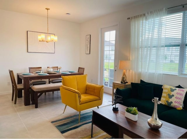 living room with plenty of natural light, a chandelier, light tile patterned floors, and baseboards