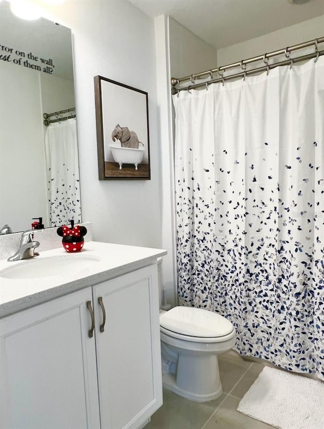 full bathroom featuring toilet, vanity, tile patterned flooring, and a shower with curtain