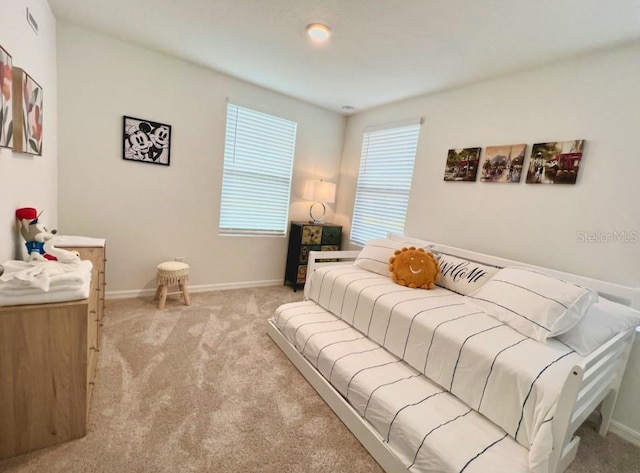 bedroom featuring light carpet and baseboards