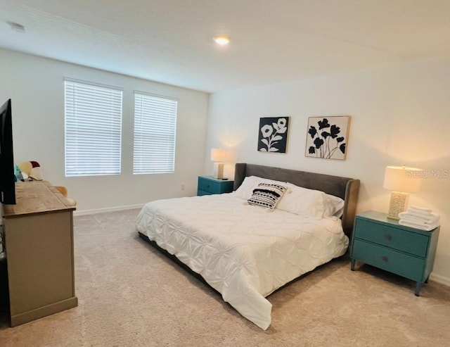 bedroom with light carpet and baseboards