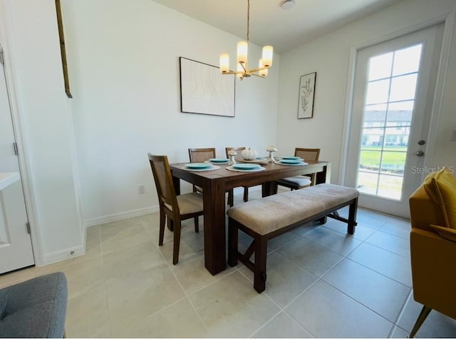 dining room featuring a chandelier, baseboards, and light tile patterned flooring