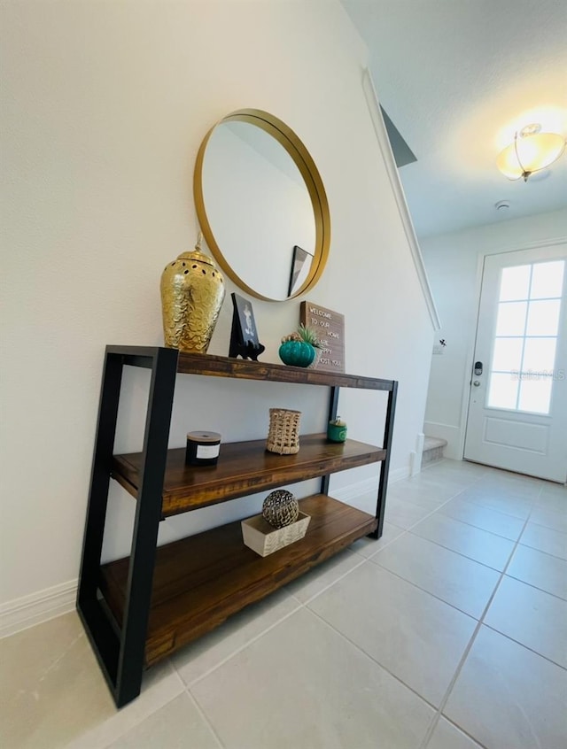 hallway featuring light tile patterned floors and baseboards