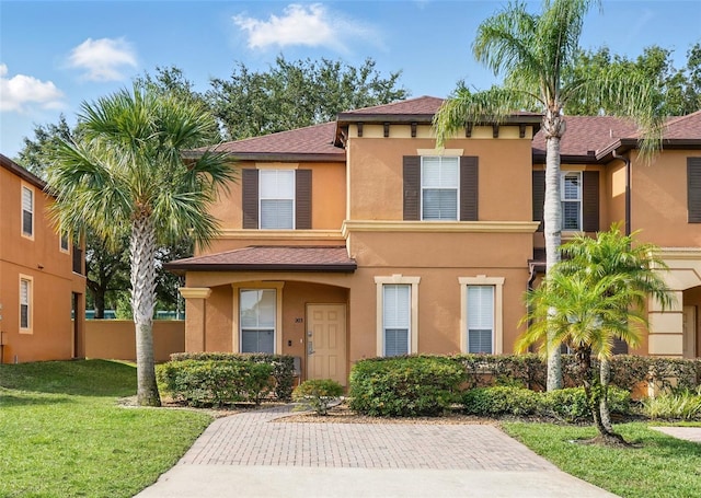 203 La Mirage St, Davenport, FL 33897 - view of front of property featuring stucco siding, a front yard, and a shingled roof