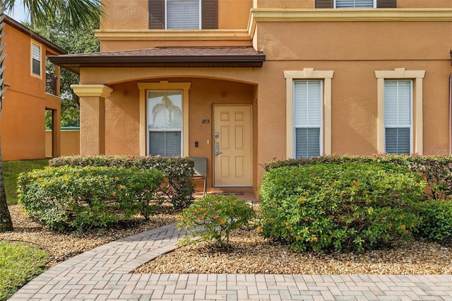 203 La Mirage St, Davenport, FL 33897 - doorway to property with stucco siding