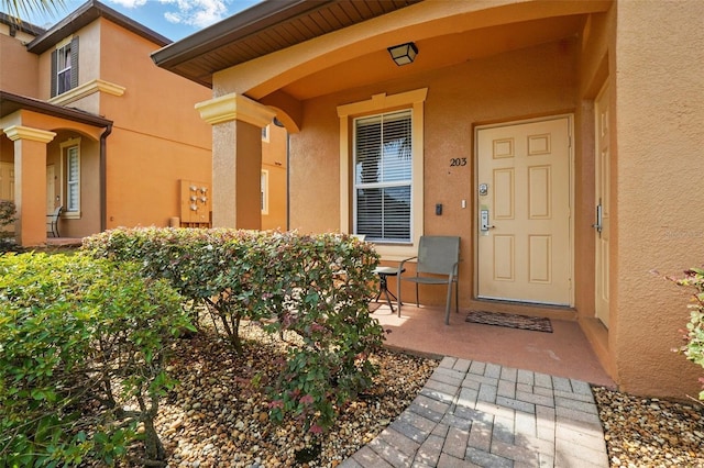 203 La Mirage St, Davenport, FL 33897 - view of exterior entry featuring stucco siding and covered porch