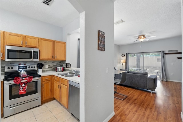 203 La Mirage St, Davenport, FL 33897 - kitchen featuring appliances with stainless steel finishes, open floor plan, a sink, arched walkways, and decorative backsplash