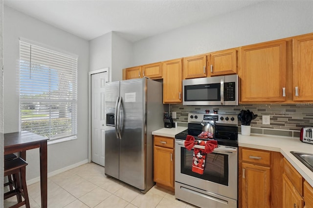203 La Mirage St, Davenport, FL 33897 - kitchen featuring appliances with stainless steel finishes, backsplash, light countertops, and light tile patterned floors