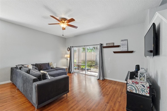 203 La Mirage St, Davenport, FL 33897 - living room featuring a ceiling fan, light wood finished floors, baseboards, and a textured ceiling