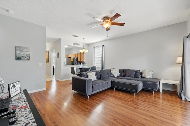 203 La Mirage St, Davenport, FL 33897 - living area with a ceiling fan, a chandelier, light wood-style floors, arched walkways, and baseboards