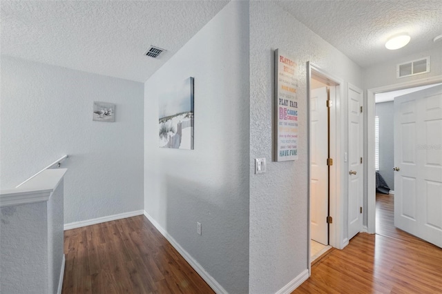 203 La Mirage St, Davenport, FL 33897 - hall featuring a textured ceiling, a textured wall, wood finished floors, and baseboards