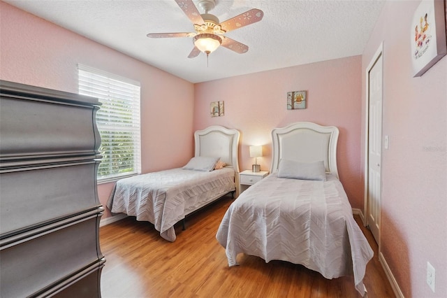 203 La Mirage St, Davenport, FL 33897 - bedroom with light wood-type flooring, ceiling fan, a textured ceiling, and baseboards