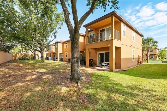 203 La Mirage St, Davenport, FL 33897 - rear view of property featuring a balcony, stucco siding, and a patio area