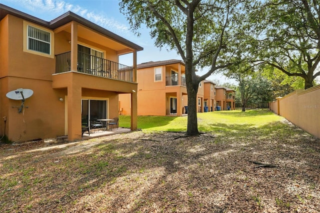 203 La Mirage St, Davenport, FL 33897 - rear view of property featuring stucco siding, a balcony, and a patio