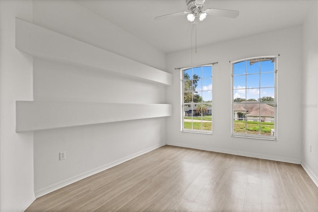 unfurnished room featuring wood finished floors, baseboards, and a ceiling fan