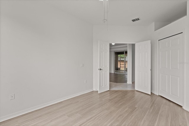 unfurnished bedroom featuring light wood-style floors, baseboards, and a closet