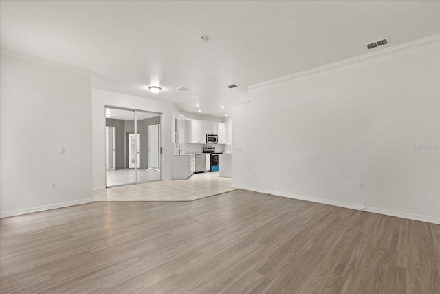 unfurnished living room with baseboards, light wood-style floors, and crown molding