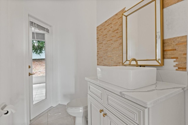 bathroom with toilet, vanity, and tile patterned floors