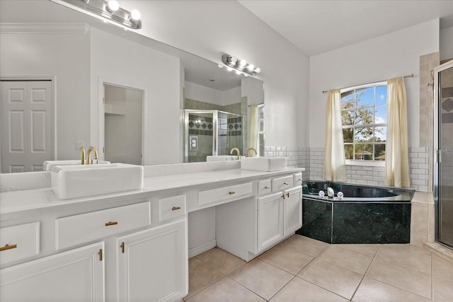 bathroom with a stall shower, double vanity, a garden tub, and tile patterned floors