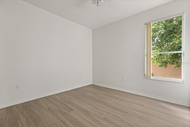 empty room with wood finished floors, ceiling fan, and baseboards