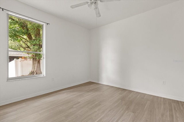 empty room with light wood finished floors, ceiling fan, and baseboards