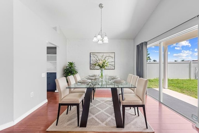3203 Herons Point Cir, Kissimmee, FL 34741 - dining space with a chandelier, vaulted ceiling, wood finished floors, and baseboards