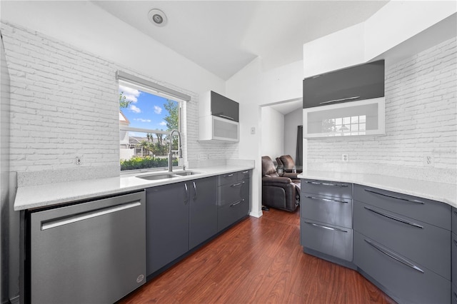 3203 Herons Point Cir, Kissimmee, FL 34741 - kitchen with stainless steel dishwasher, a sink, dark wood-style flooring, modern cabinets, and brick wall