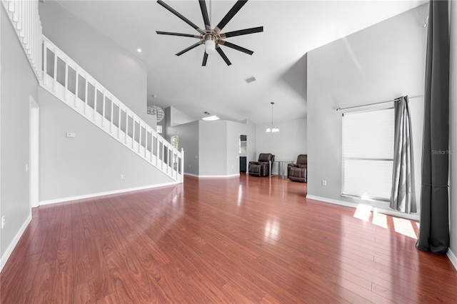3203 Herons Point Cir, Kissimmee, FL 34741 - unfurnished living room featuring high vaulted ceiling, stairs, a ceiling fan, wood finished floors, and baseboards