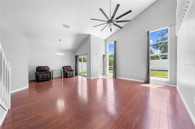 3203 Herons Point Cir, Kissimmee, FL 34741 - unfurnished living room featuring high vaulted ceiling, a chandelier, wood finished floors, a ceiling fan, and baseboards